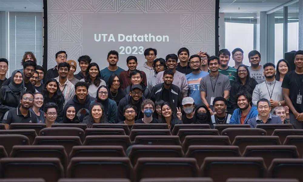 group of student posing in front of UTA Datathon 2023 screen