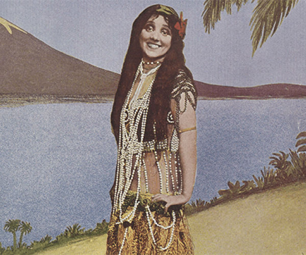girl dressed in Hawaiian wear on an island surrounded by palm trees