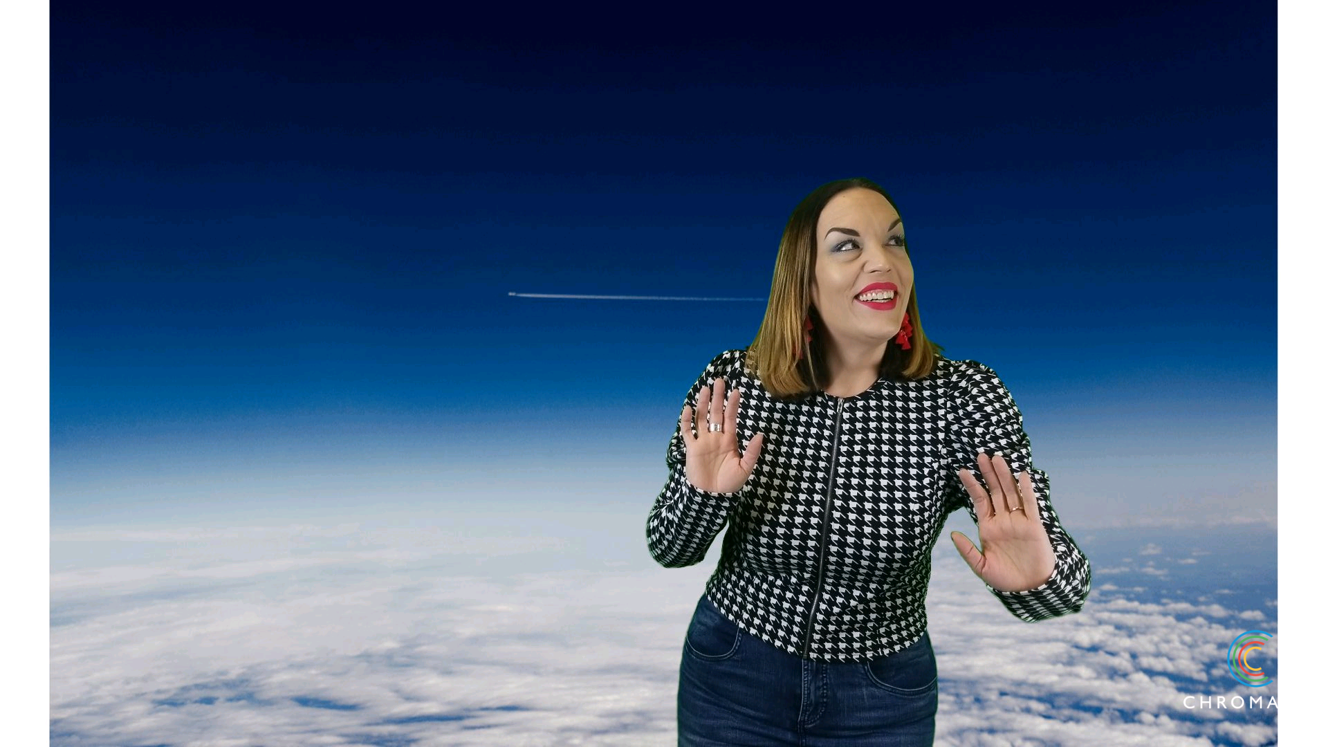 Tessa poses in front of a green screen which has been keyed to show a skyscape above the cloudline