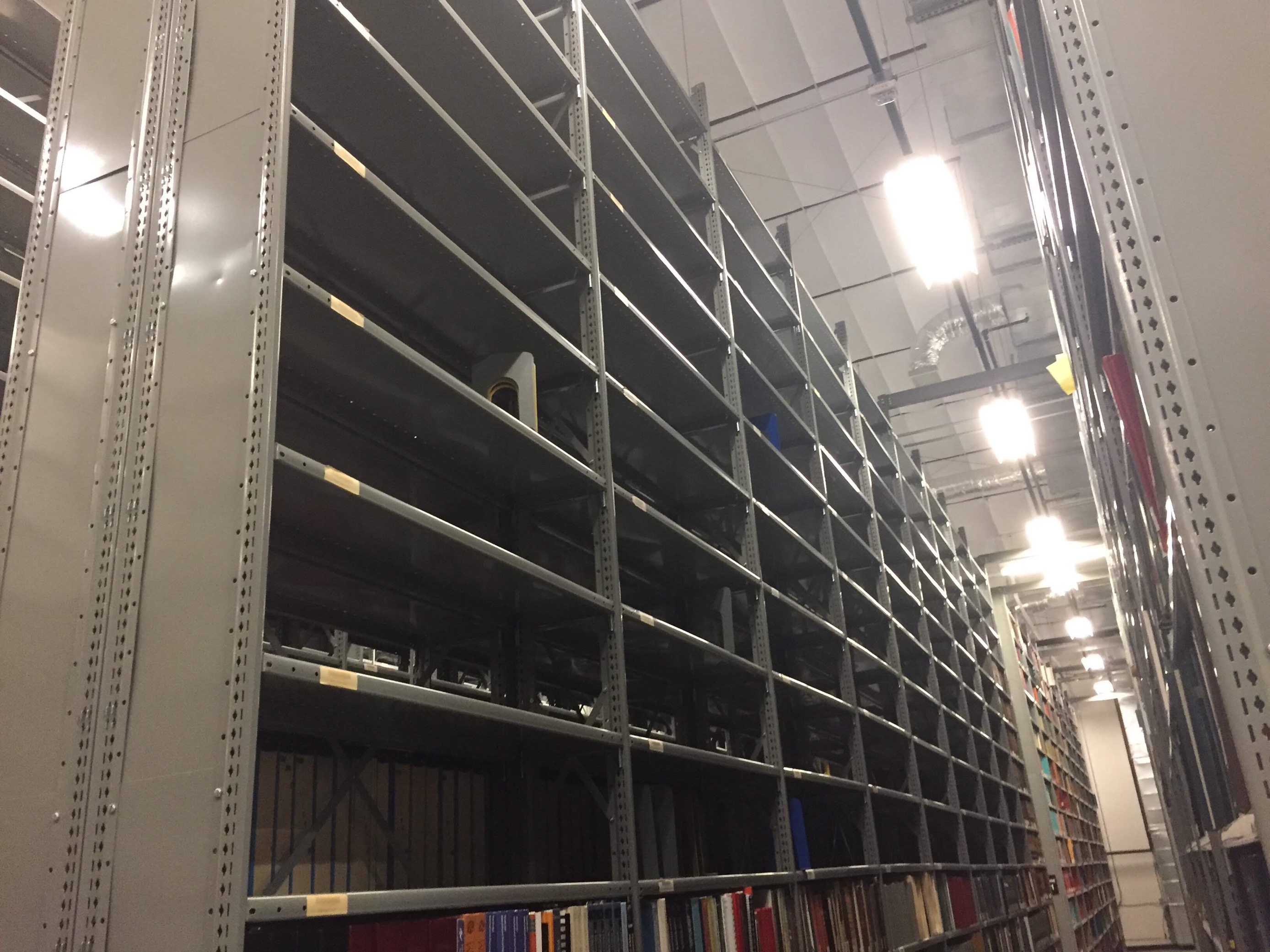 half empty shelves in the library collections depository