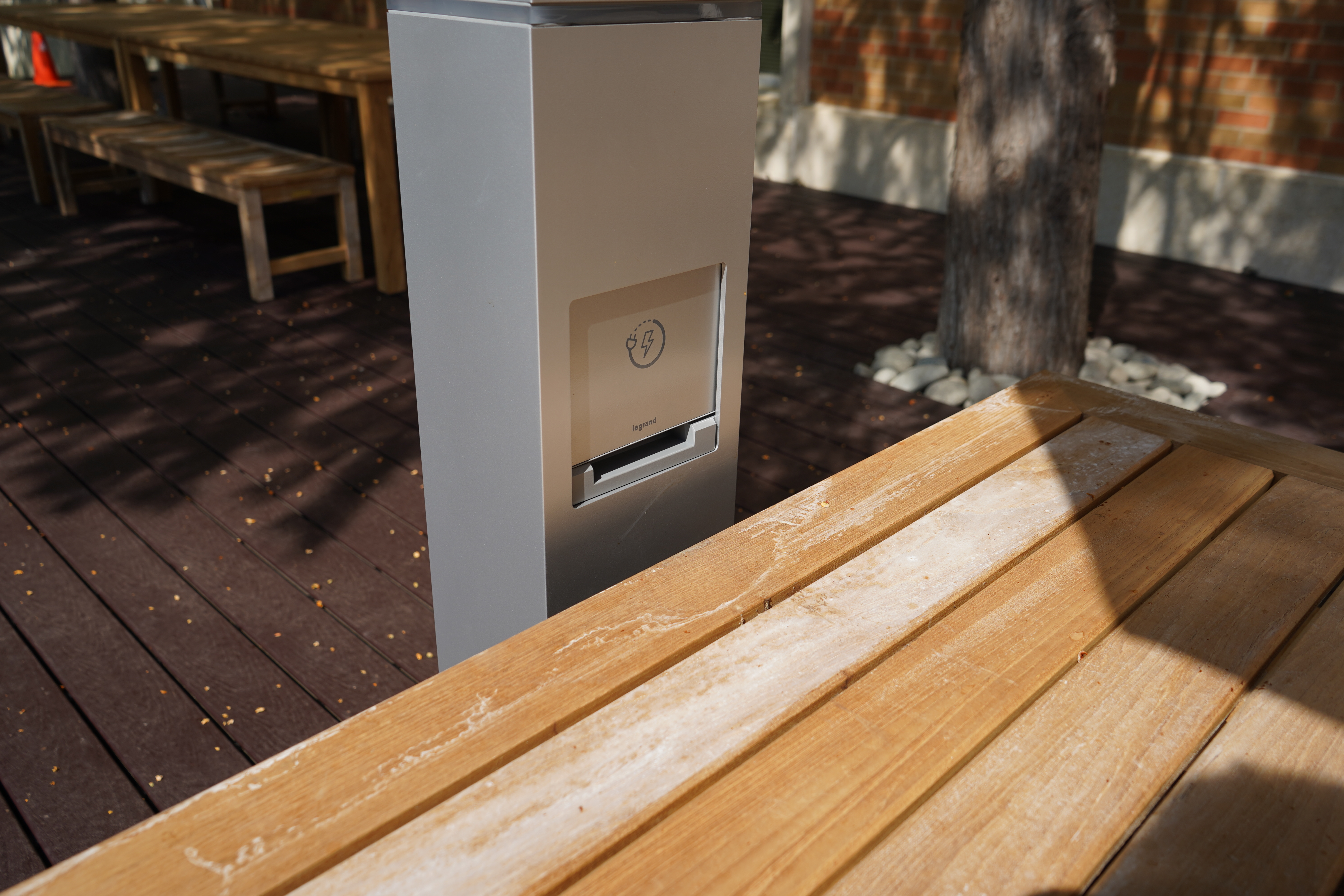 a charging station at the end of a wood table; a new deck can be seen in the background