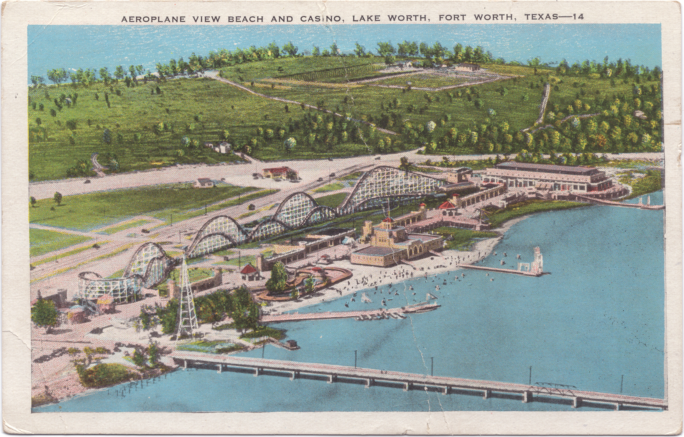 The postcard features a drawing of an aerial view of the casino and a large rollercoaster with the lake in front of it and a field behind it.