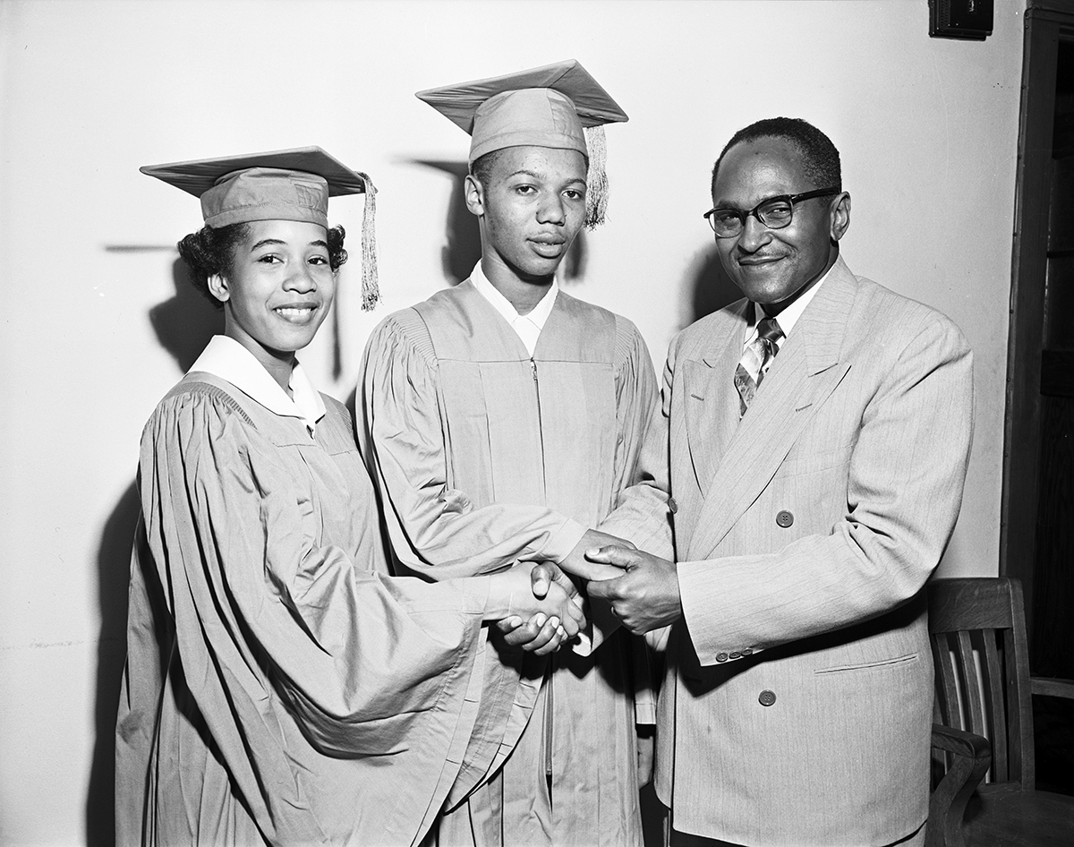 H. L. King, principal of I.M. Terrell High School, is shown congratulating the school's two honor graduates, Cecil Johnson, winner of the scholarship for boys, and Barbara Thornton, girls' scholarship winner.