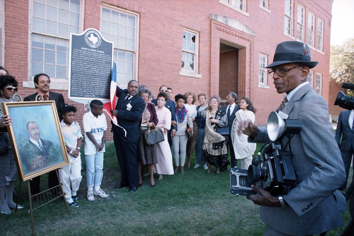 Photographer Calvin Littlejohn, right, who taught at James E. Guinn School in the 1930s, is seen at the unveiling of the historical marker for the school. A painted portrait of James E. Guinn is seen at left.
