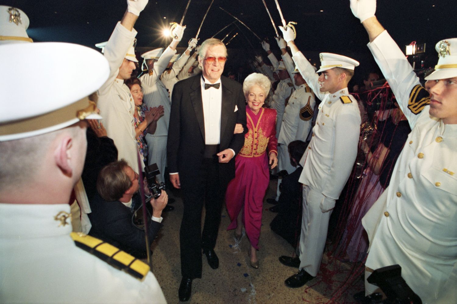 Governor Ann Richards enters the first Inauguration Ball under a saber arch, held up by unidentified cadets, with her father, Cecil Willis.