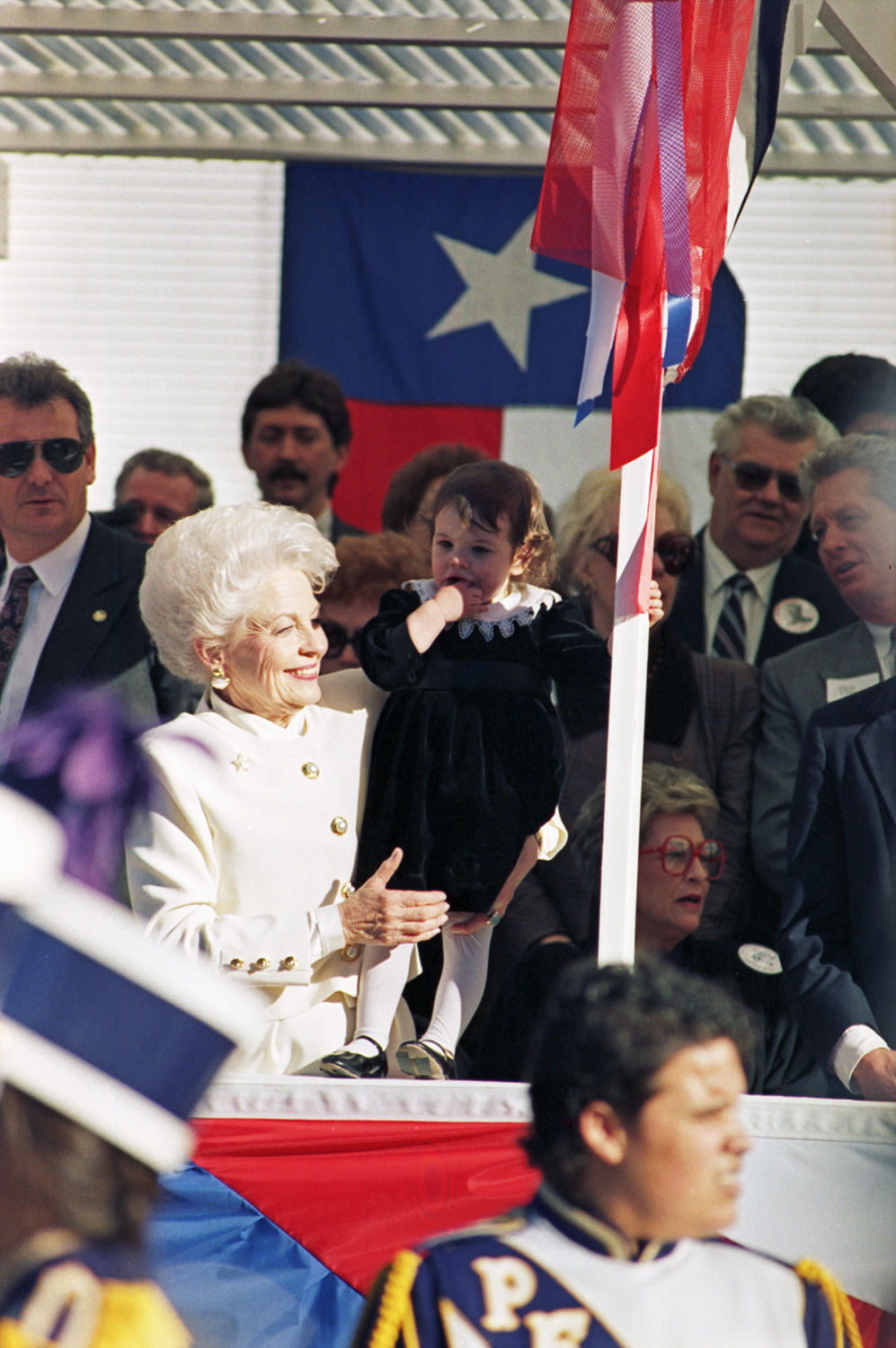 Inauguration of Texas Governor Ann Richards in Austin, Texas. Richards is seen holding her granddaughter (possibly Jennifer Richards) in front of the Texas State Capitol building.