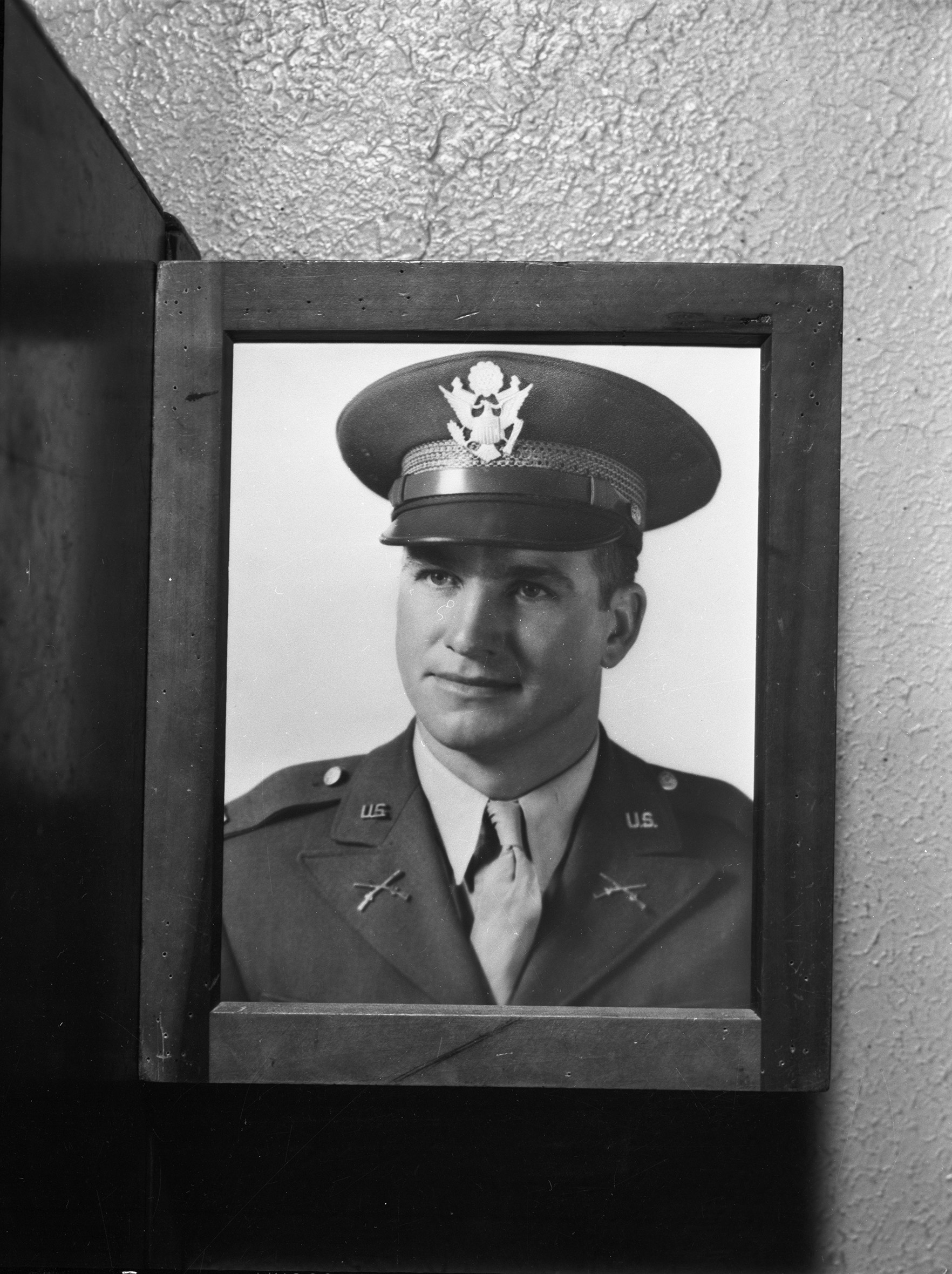 A copy of Captain Slaughter's official portrait photograph in a wooden frame. He is shown dressed in military uniform.