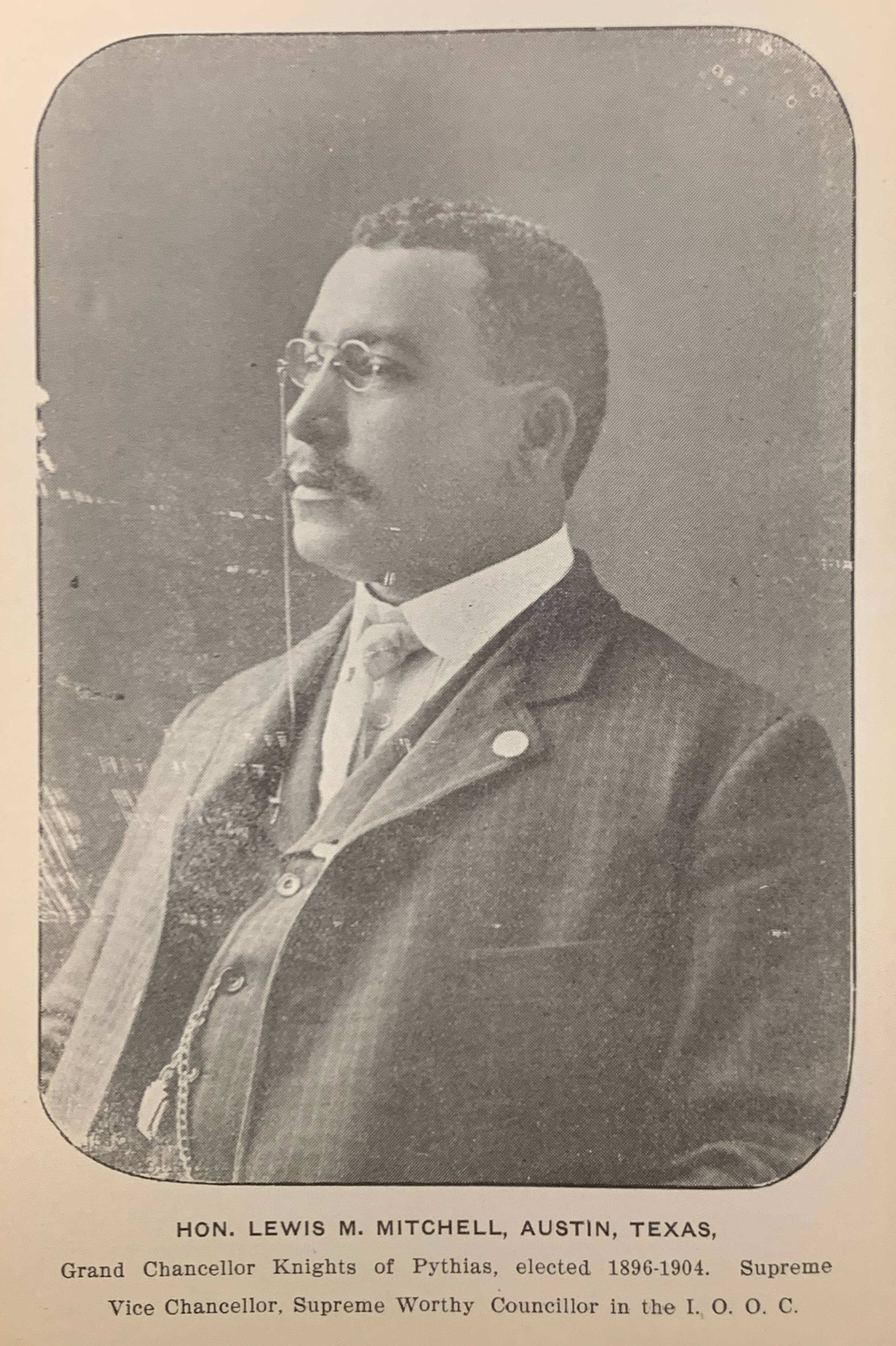African-American man in suit and glasses, 1900's. Text reads: Hon. Lewis M. Mitchell, Austin. Texas, Grand Chancellor Knights of Pythias, elected 1896-1904. Supreme Vice Chancellor, Supreme Worthy Councilor in the I.O.O.C.