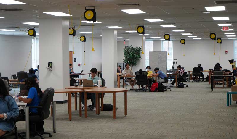 3rd floor of library with students studying at tables