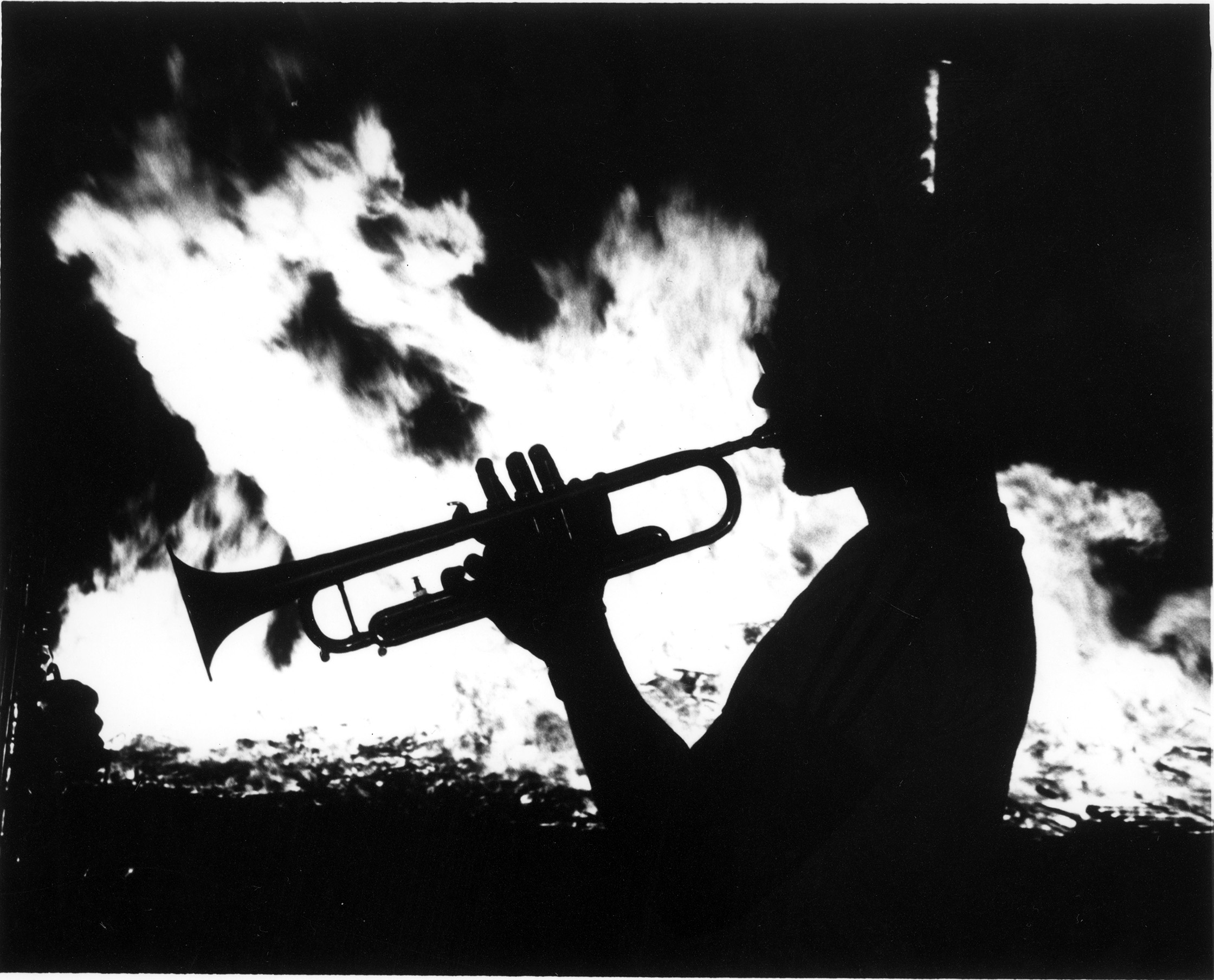 Trumpeter silhoutetted by the homecoming bonfire.