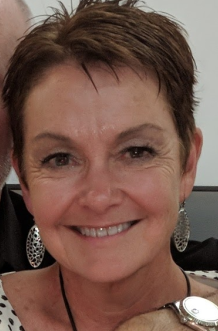 Person with short hair and earrings