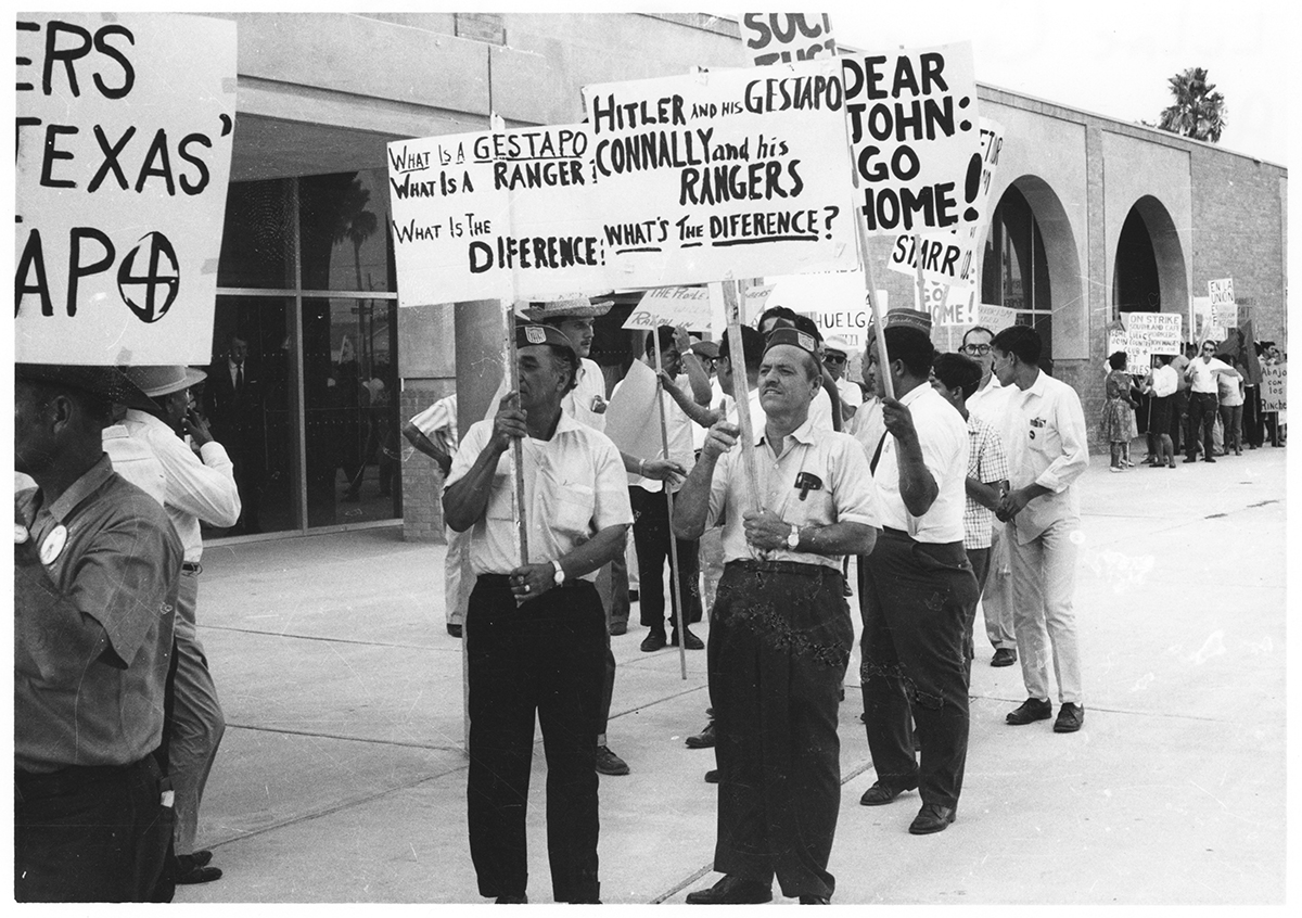 American G.I. Forum Picketers at LULAC Convention, 1967. A group of men in white shirts and dark pants carry signs protesting the Texas Rangers.