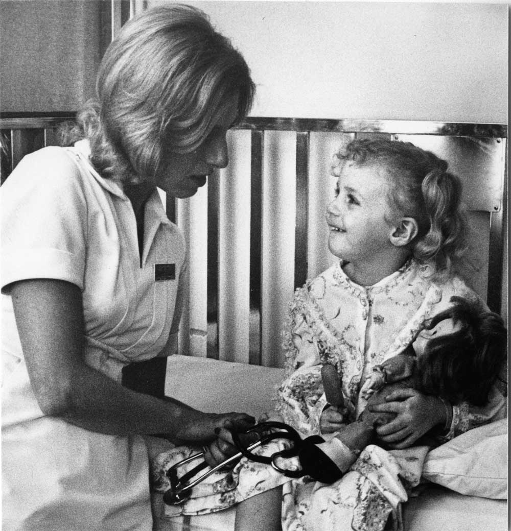 Nurse with a girl holding a doll