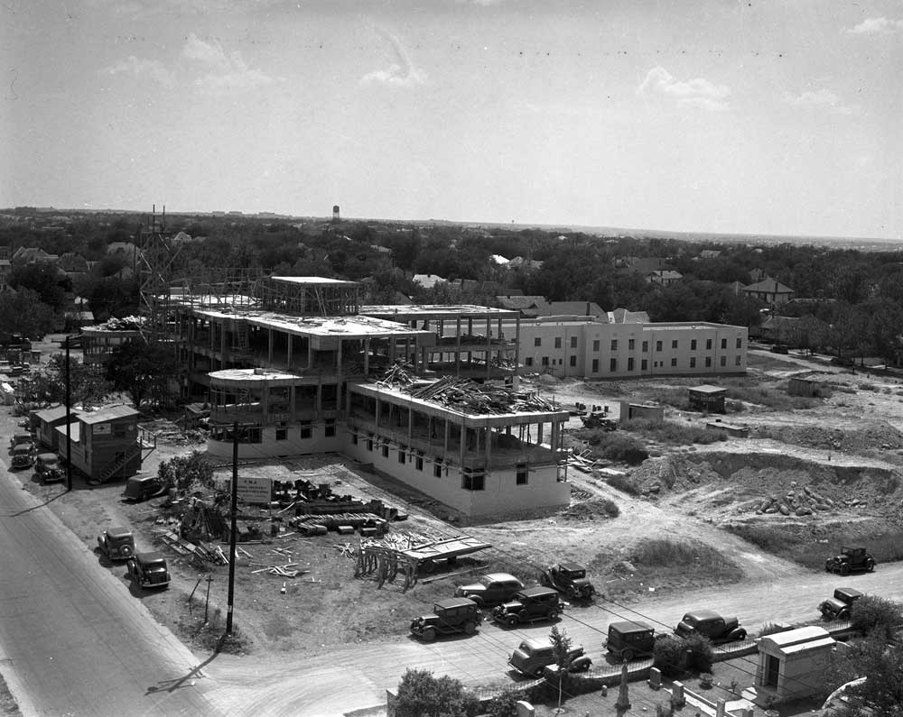 Large building under construction viewed from an elevated location across the street