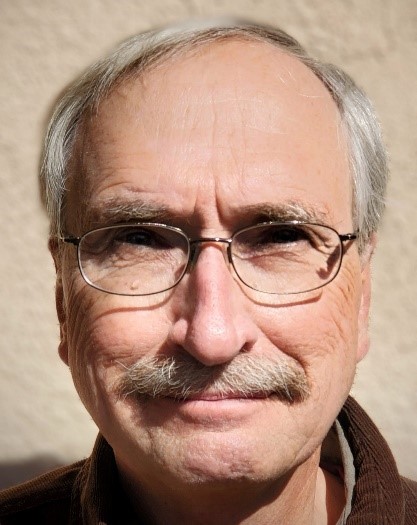 Head shot of a man with glasses, white hair, and a mustache