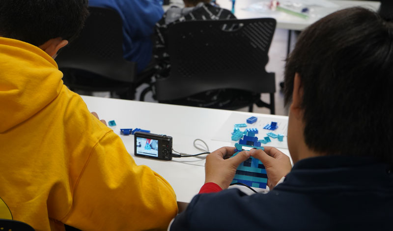 students creating stop motion video with Legos