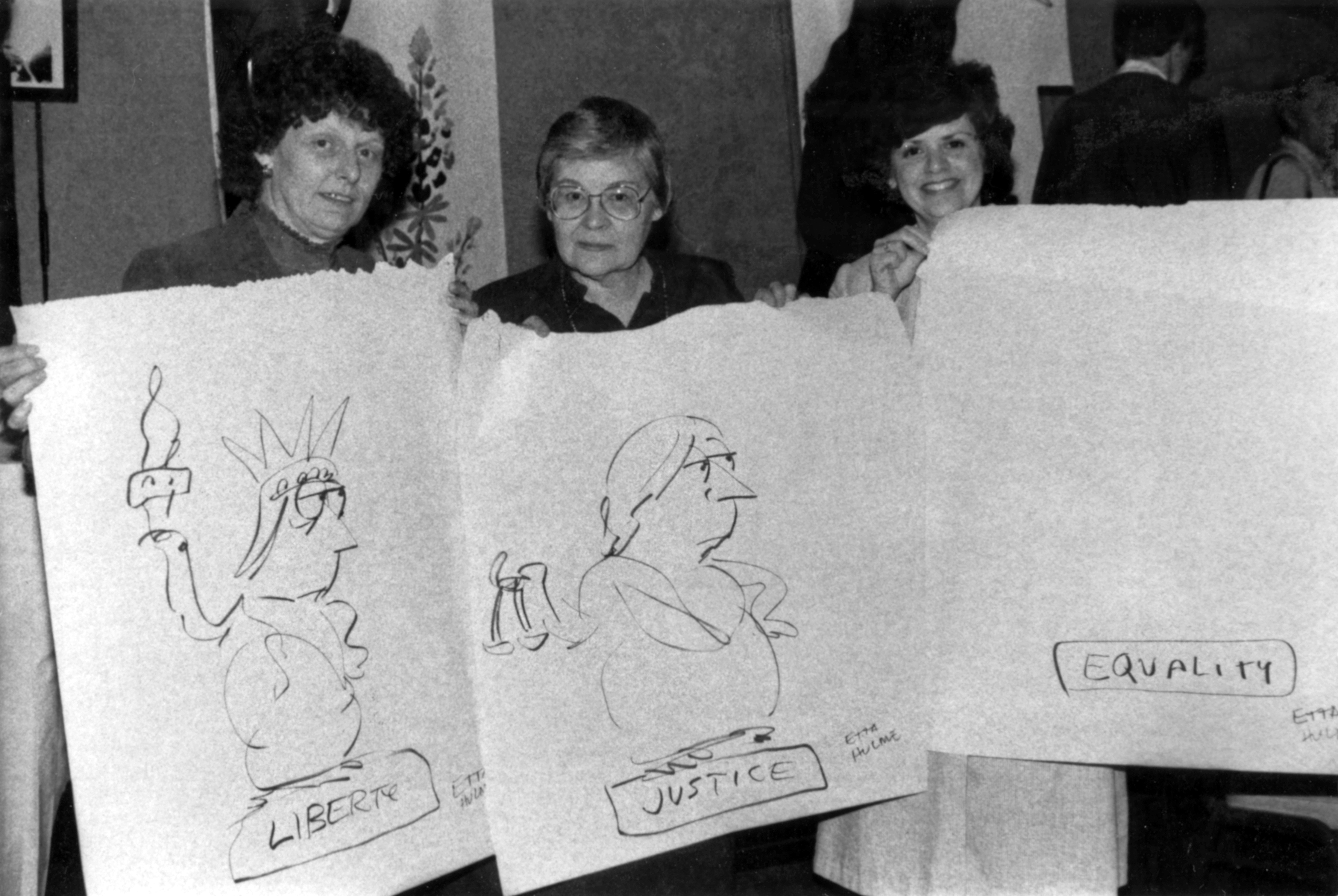 Three women display cartoons drawn by Etta Hulme, Fort Worth Star-Telegram editorial cartoonist, which depict “Liberty, Justice, Equality”