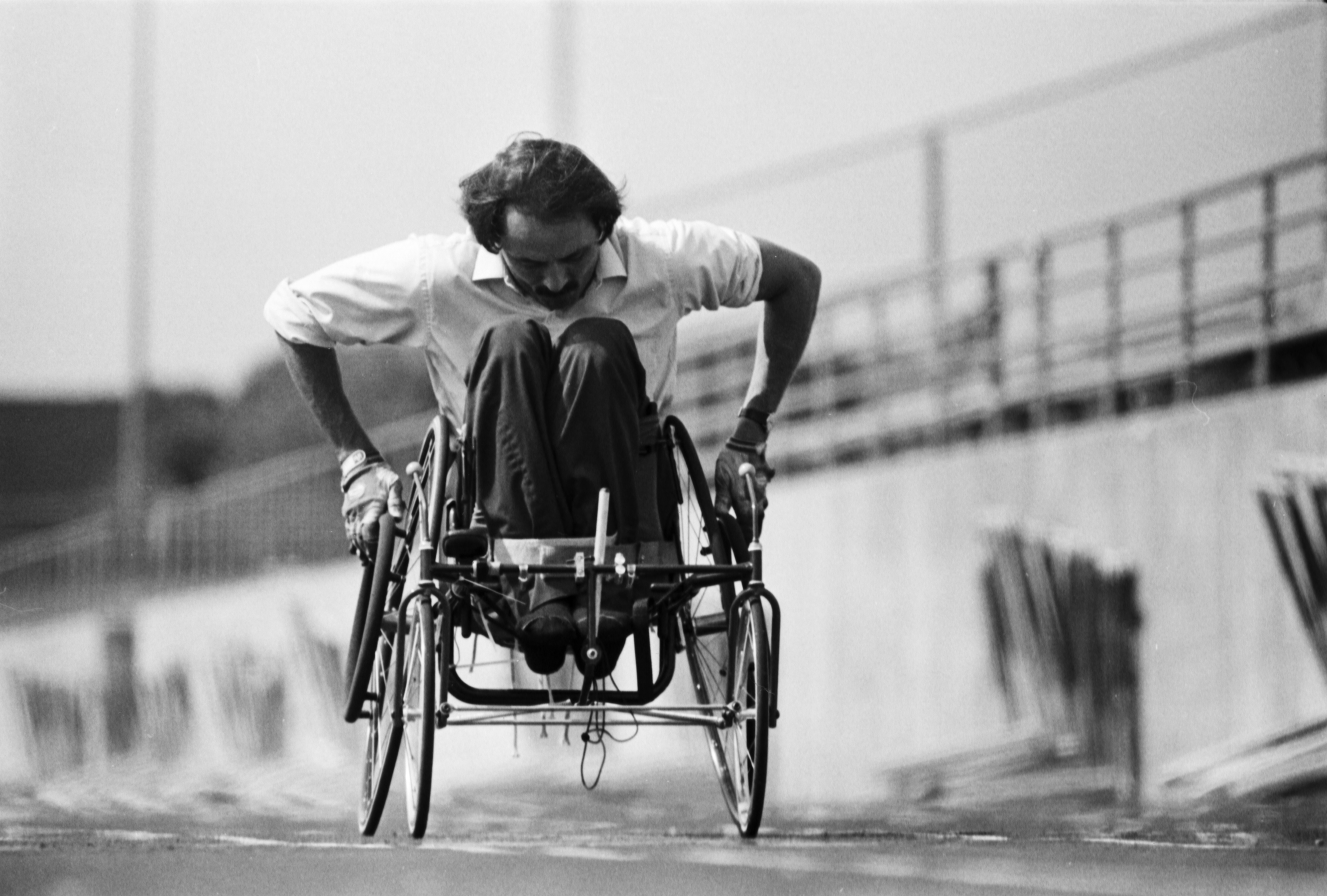 Black and white photo of a wheelchair user on a track practicing.