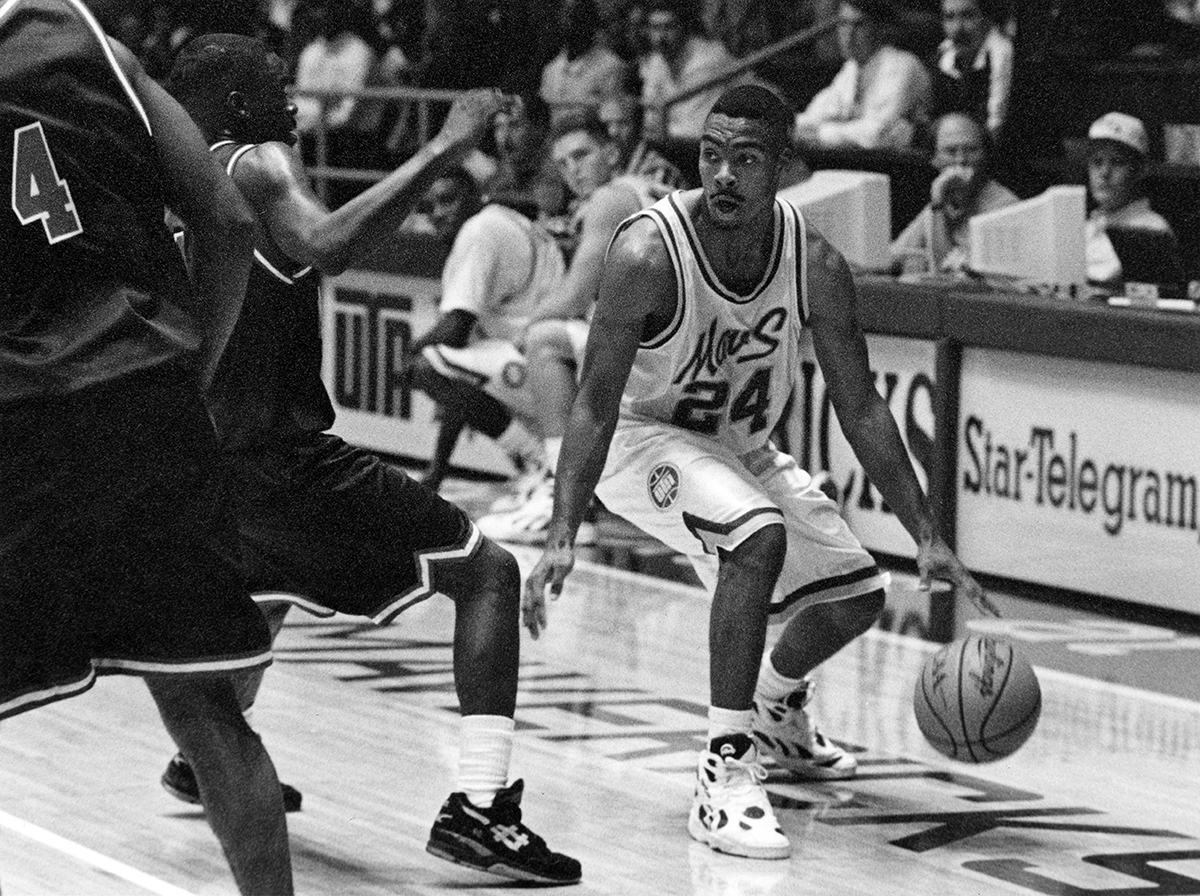 Black and white photo of a basketball player during a game with the basketball.