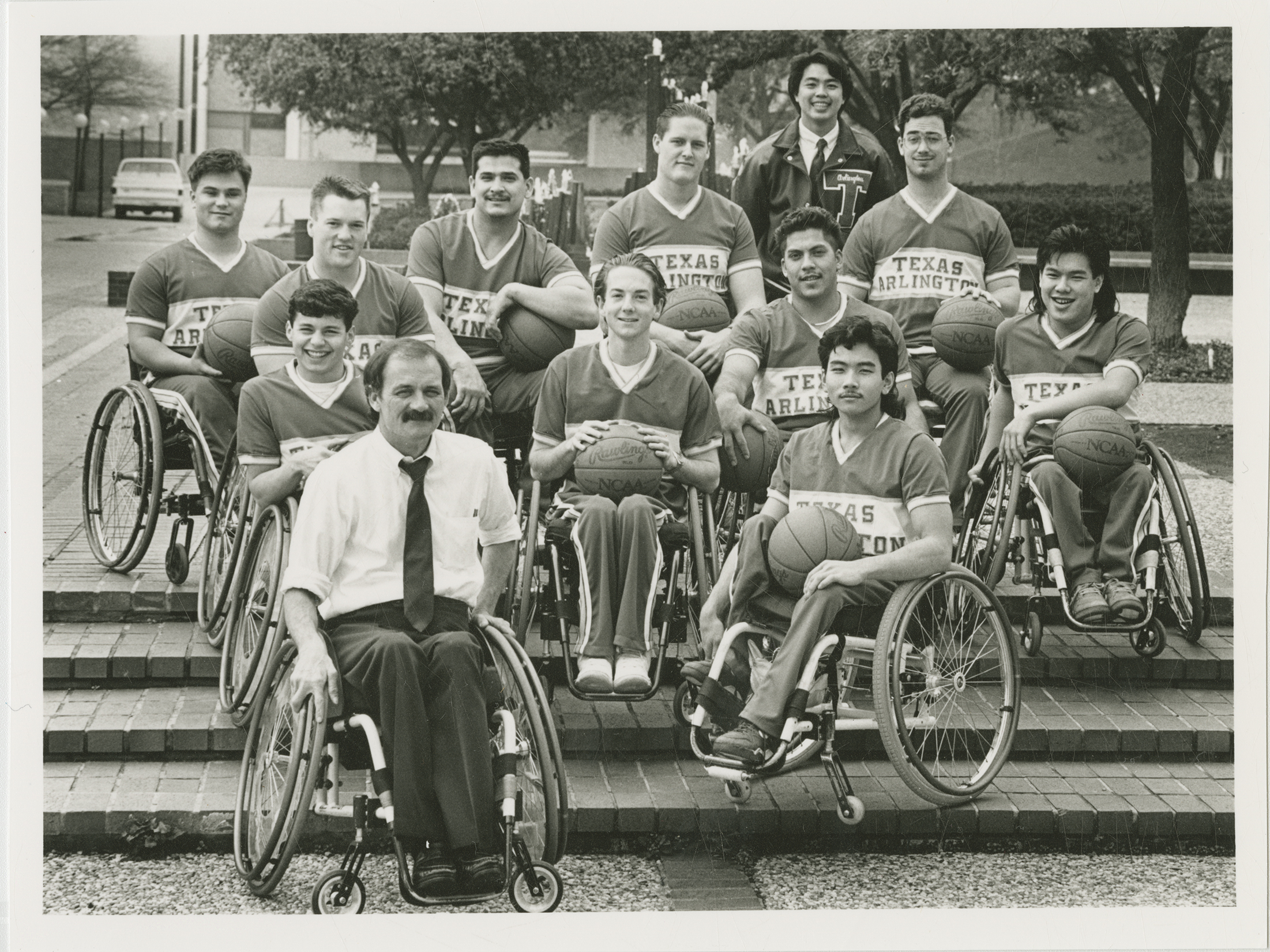 Sepia photo of a group of wheelchair basketball players posed for a portrait.