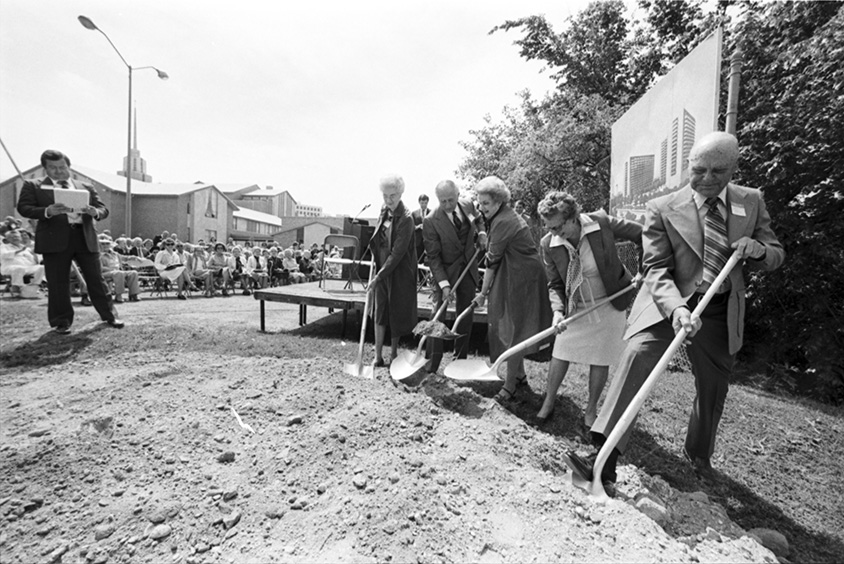 People digging with shovels in dirt.