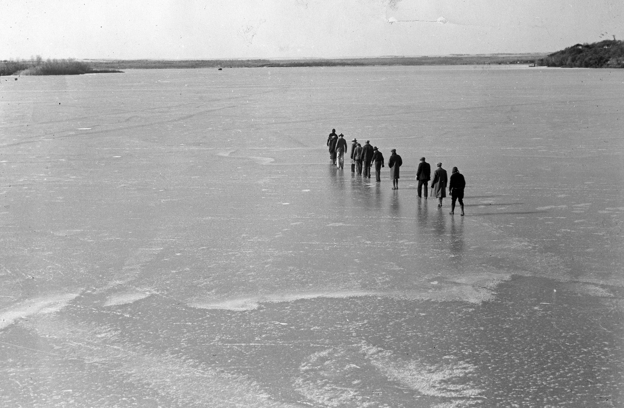People walking across an iced-over lake.