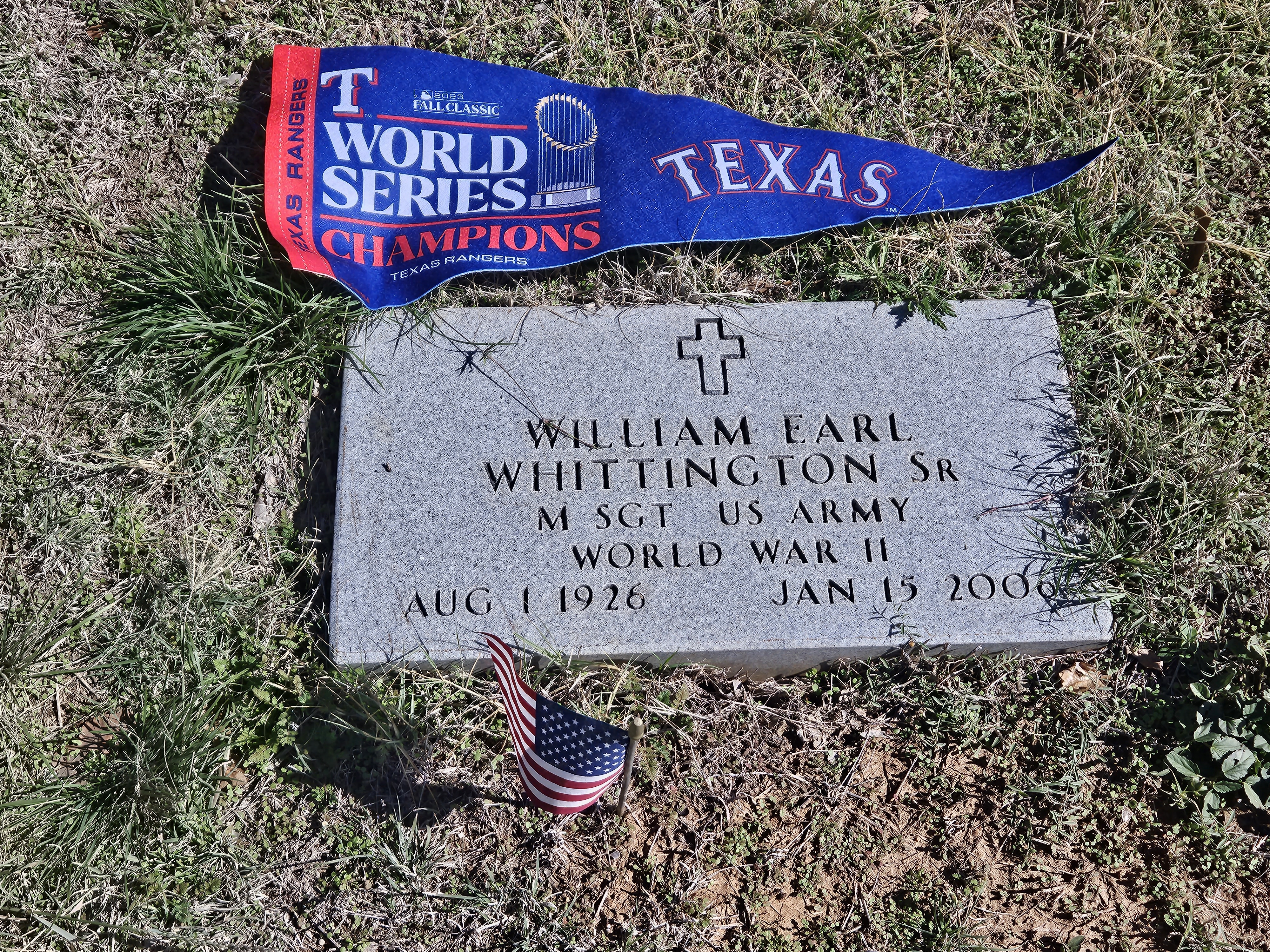 Image of headstone of William Earl Whittington, Sr. with a Texas Rangers World Series pennant above it. 