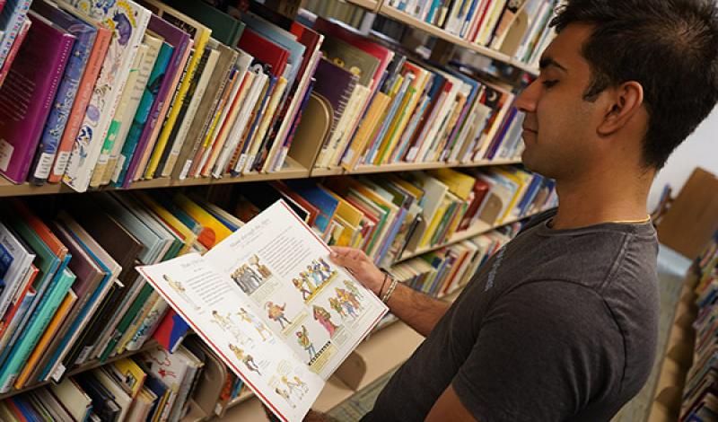 student looking at a book in the Reading Resources section
