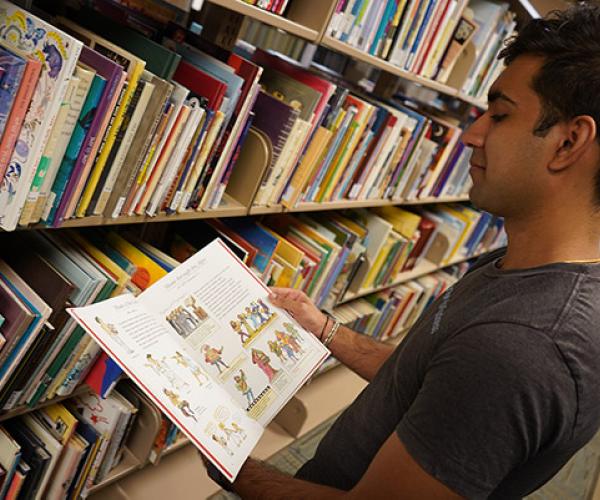 student looking at a book in the Reading Resources section