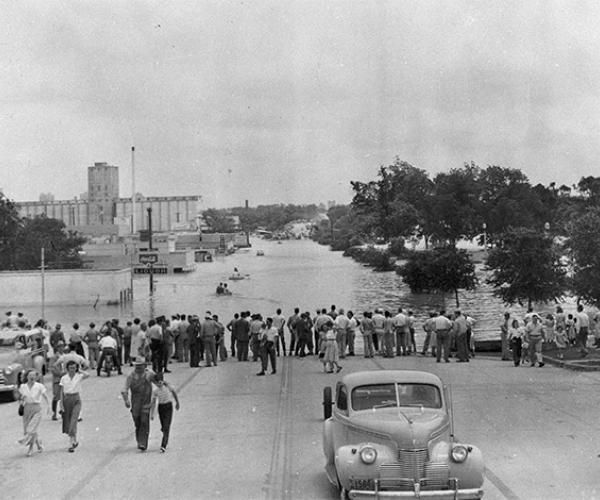 People lining street at water's edge during flood of May, 1949, Fort Worth