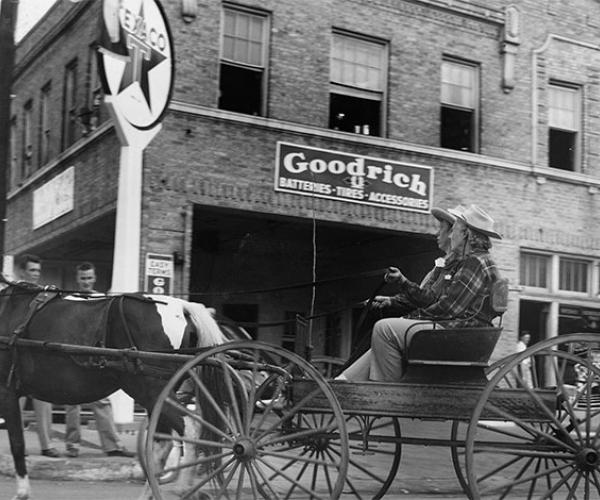 Horse and buggy passing in front of Vandergriff Chevrolet in 1947