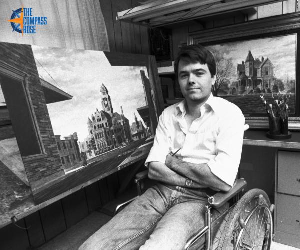 Lead image showing an artist in a wheelchair with his paintings surrounding him.