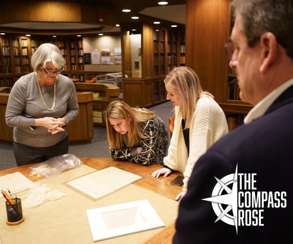 Staff and visitors in UTA Special Collections reviewing manuscript materials.