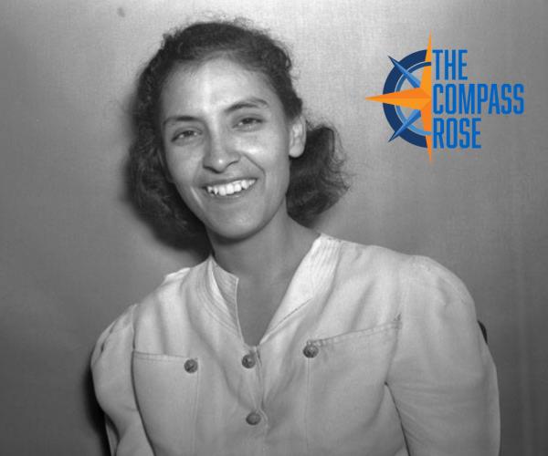 Portrait photograph of a woman wearing a white shirt looking at the camera and smiling with The Compass Rose logo in the top right corner