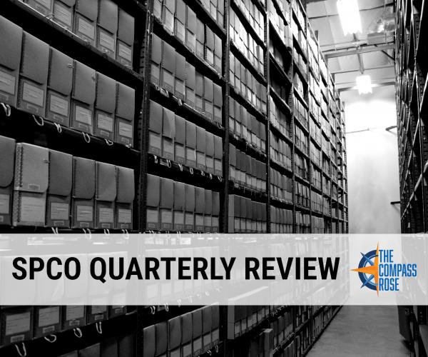 Black and white photograph of a row of boxes in an archive with the words "SPCO QUARTERLY REVIEW" superimposed over the image with a blue and orange Compass Rose logo next to the text.