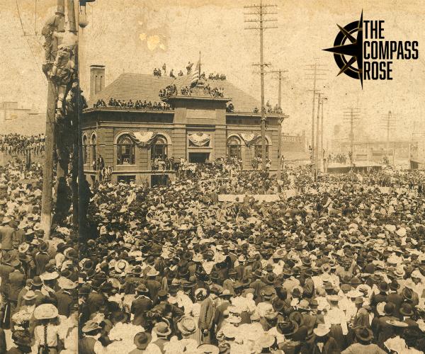 Sepia photograph showing thousands of people in a crowd during President Theodore Roosevelt's visit to Fort Worth. The black Compass Rose logo is seen at top right.