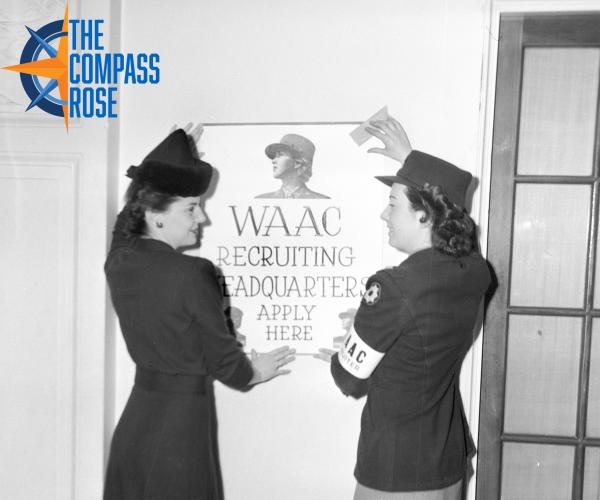 Two women in military uniform putting up a poster that states, "WAAC recruiting headquarters apply here."