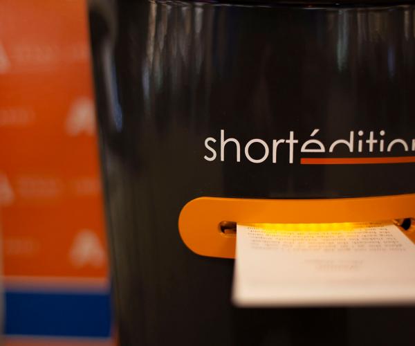 short edition short story dispenser printing a story, glowing orange