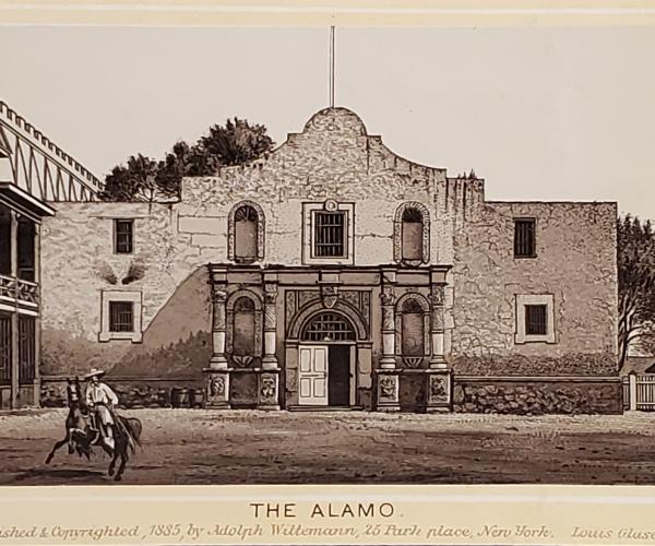Image of the Alamo with a man riding the horse in front. 