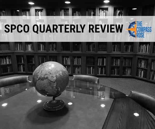 A table with a globe, with bookcases in the background, with the banner SPCO Quarterly Review and The Compass Rose logo in blue and orange