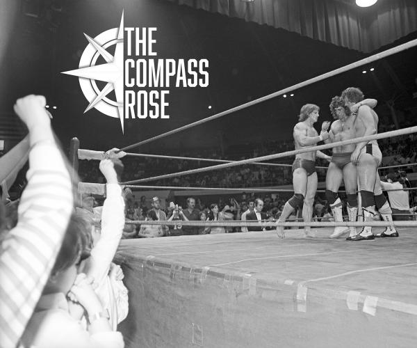 Black and white photo of three wrestlers in a wrestling ring surrounded by fans.